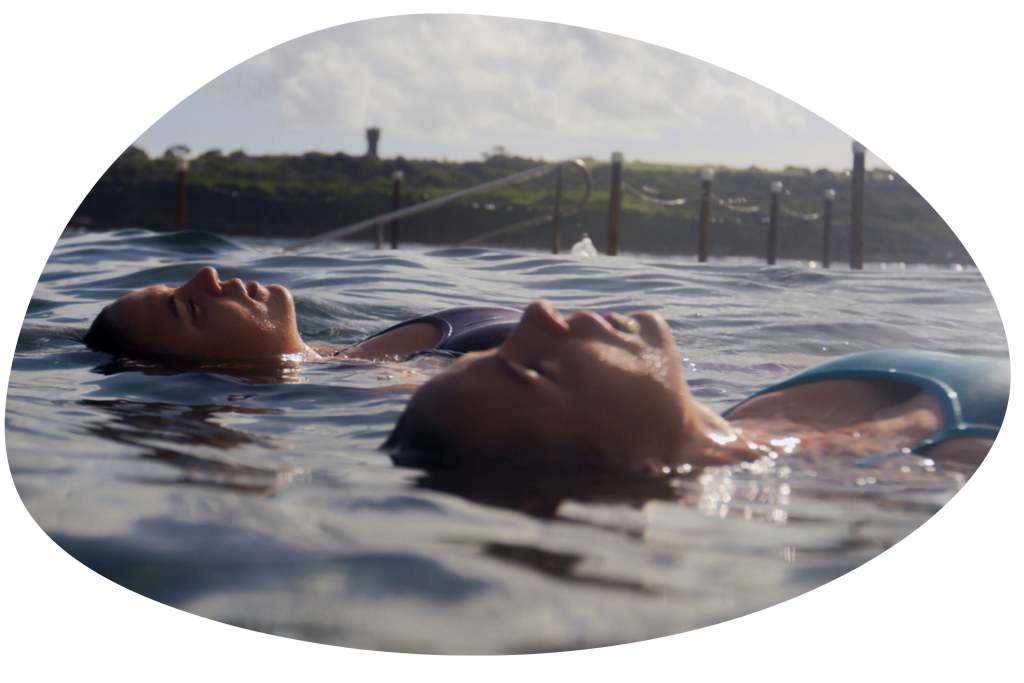 Two people floating on their backs while swimming from the documentary Nansie.